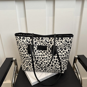 Large leopard print tote bag with black shoulder straps and center leather patch