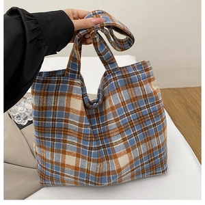 Close-up of a blue and orange plaid wool tote bag showing thick textured fabric