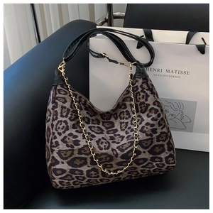 Detail of hobo bag with leopard print, faux leather strap, and gold-tone chain link