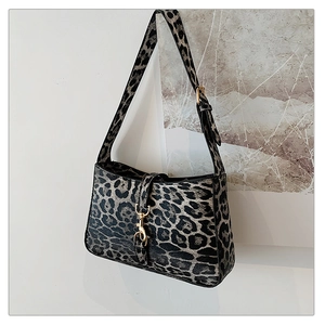Detail of grey leopard print shoulder bag featuring a gold lobster clasp and adjustable strap