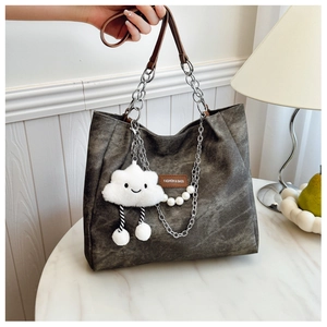 Vintage dark gray canvas tote bag with chain strap and cute cloud charm on white marble