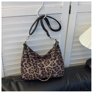 Macro shot of leopard print shoulder bag with gold metal chain and zipper detail