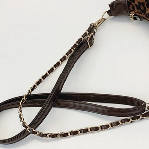 Detail of adjustable leather strap and golden chain on leopard print crossbody bag