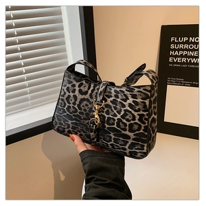 Detail of leopard print handbag with golden piston lock and stylish texture