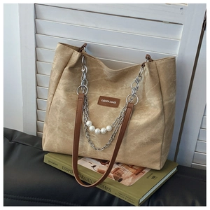 Detail of khaki canvas tote bag with pearl chain strap and leather fashion label