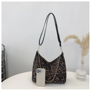 Leopard print hobo bag with gold chain and leather strap next to a smartphone