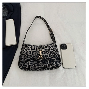 Close-up of leopard print shoulder bag with golden piston clasp and hobo silhouette