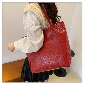 Detailed texture of red crocodile embossed leather on a spacious shoulder tote bag