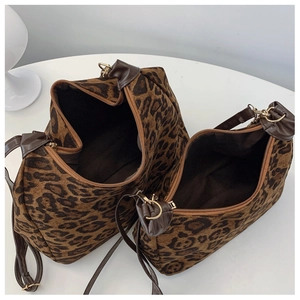 Close-up of leopard print shoulder bags with brown leather straps and gold metal hardware