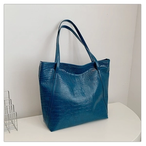 Detail of blue crocodile pattern tote bag with long shoulder straps for daily commute