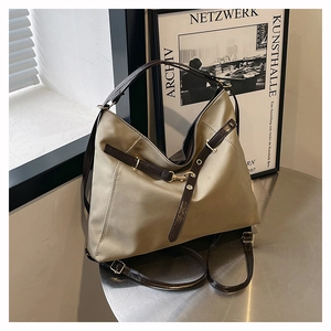 Detail of adjustable faux leather shoulder strap with gold hardware on a nylon tote bag