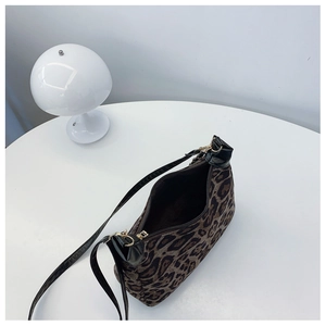 Detail view of leopard print shoulder bag with gold zipper and black leather trim