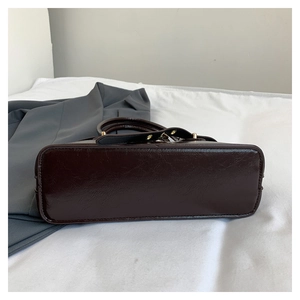 Detail view of the wide rectangular base of this vintage dark brown tote bag