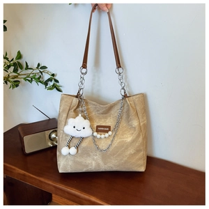 Detail of khaki canvas tote bag with pearl chain decoration and cloud plush pendant