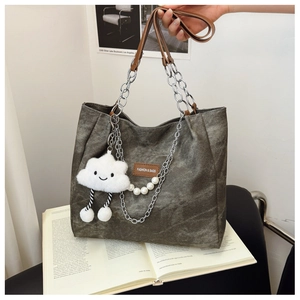 Detail of dark grey-green canvas tote bag with chain strap and cute cloud charm