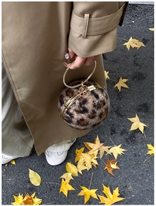 Nahaufnahme der Leopardenmuster-Kugelhandtasche mit Strassgriff und goldenem Metallrahmen