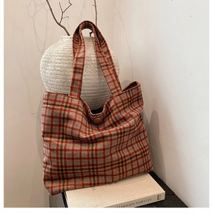 Detail of vintage plaid wool tote bag with orange tartan pattern and button closure