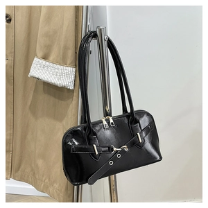 Detail of black glossy leather handbag with gold zipper and Fashion embossed text