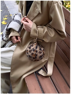 Detailaufnahme der Leoparden-Plüschtextur und des goldenen Ringgriffs einer Kugel-Tasche