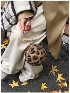 Detail der kugelförmigen Handtasche mit Leopardenmuster und glitzerndem Strass-Goldgriff
