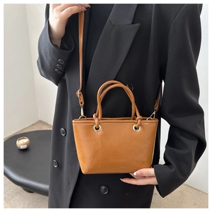 Nahaufnahme der karamellfarbenen PU-Leder Eimertasche mit Ösen und Fashion & Bags Prägung