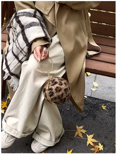 Detail der Abendtasche mit Leopardenmuster, Kugelform und Kristall-Goldgriff im Fokus