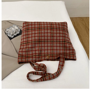 Detailed view of the plaid tote bag showing the thick wool fabric and button closure