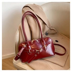 Close-up of deep red glossy patent leather Boston bag with embossed FASHION lettering
