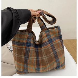 Detail of plaid wool tote bag showing thick texture and brown button closure