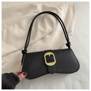 Détail d'un sac d'épaule en cuir noir avec une grande boucle dorée texturée élégante