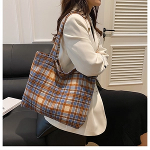 Detail of vintage plaid wool tote bag showing secure snap closure and textured fabric