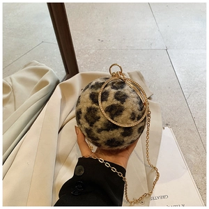 Detail der kugelförmigen Handtasche aus Leoparden-Kunstfell mit goldenem Griff und Kette