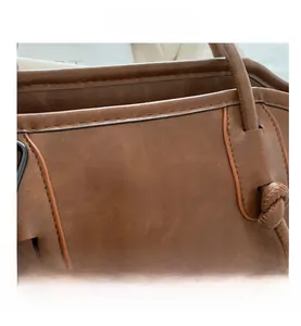 Detail of vintage brown tote bag with white FASHION print and knot handle texture