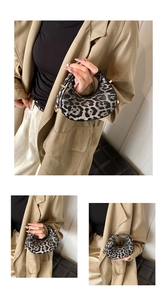 Detail of leopard print crescent bag with sleek gold-tone hardware and animal pattern