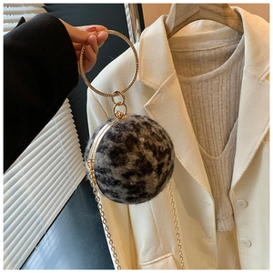 Makroansicht der Leoparden-Kugelhandtasche mit Goldgriff und schicker Metallkette