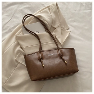 Detail of vintage brown leather tote bag with white FASHION print and knotted strap