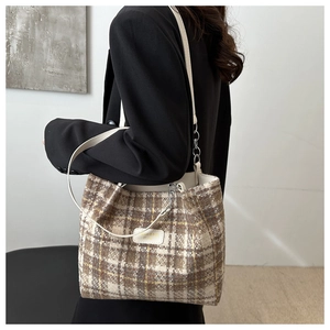 Détail du sac cabas en tweed à carreaux montrant la texture tissée et la bandoulière