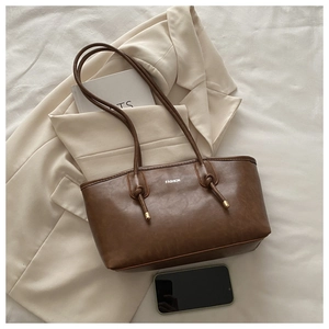 Top view of a brown vintage tote bag with fashion lettering and knotted shoulder strap