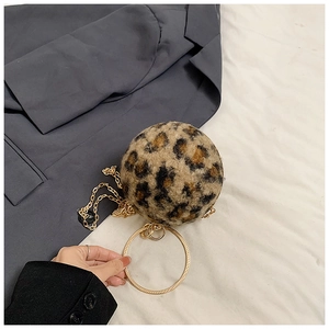 Detailaufnahme der Leopardenmuster Rundtasche mit goldenen Ringgriffen und Kettenriemen