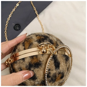 Nahaufnahme der Abendtasche in Kugelform mit Leopardenmuster und Kristallringgriff in Gold