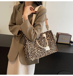 Detail view of leopard print tote bag featuring a front pocket and wide shoulder strap