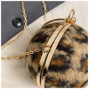 Detail der kugelförmigen Clutch mit Leopardenmuster, Goldverschluss und Metallkette