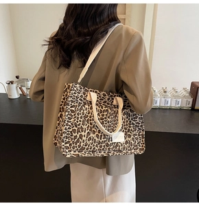 Detail of large leopard print tote bag with cream handles and branding tag