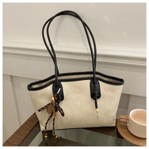Detail of off-white tote bag with black trim and elegant tennis racket charm