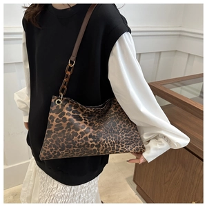 Detail of leopard print shoulder bag with brown leather and amber acrylic chain strap