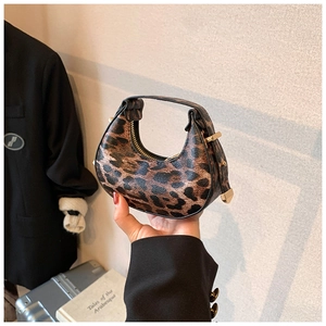 Close-up of mini crescent moon bag with leopard print texture and zipper detail