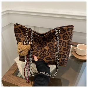 Dettaglio borsa tote leopardata con tracolla a catena e ciondolo a forma di orso