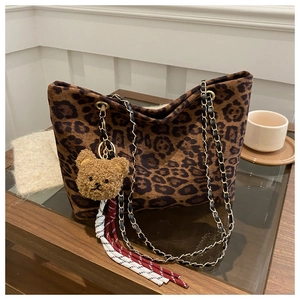 Dettaglio della borsa tote leopardata con ciondolo a orsetto e tracolla a catena