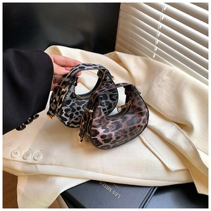 Detail of mini crescent leopard print handbags with gold hardware and texture