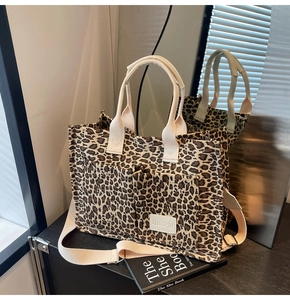 Detail of leopard print canvas tote bag featuring JINGPIN leather label and sturdy straps